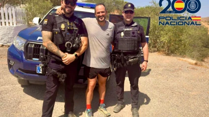 El senderista con los agentes que le rescataron