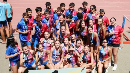 Chicos y chicas del Atletismo Delsur La Palma posando en la misma instalación malagueña
