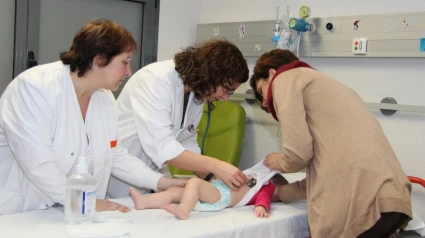 doctoras atienden en un bebé en una cama de hospital
