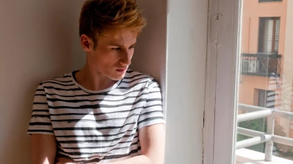 FK31H0 FK31H0 Young man by the window, leaned against the wall.