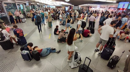 Cientos de personas esperan la salida de su tren en la estación de Atocha en Madrid