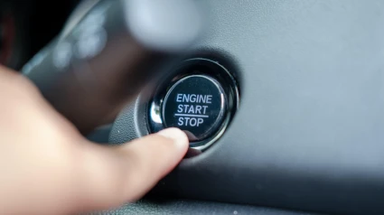 Dedo masculino presionando el botón de arranque y parada del motor