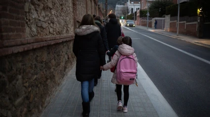 Una mujer lleva de la mano a una niña al colegio, en una imagen de archivo.