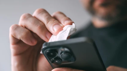 Un hombre limpiando su teléfono móvil después de mojarse