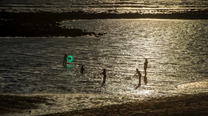 Niños jugando con un flotador en la arena de la playa de Tarifa
