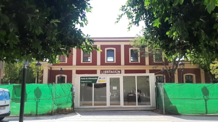 La oficina de atención al público de Adif en Lorca, de color blanco, ante la fachada de la estación de trenes de Sutullena