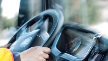 Manos del conductor del camión sosteniendo el volante con movimiento, velocidad, movimiento, enfoque selectivo