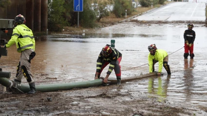 Efectivos de la Unidad Militar de Emergencias trabajan en una carretera inundada próxima a la localidad zaragozana de Grisén este sábado. EFE/ Javier Belver