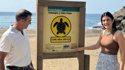La concejala de Medio Ambiente en una playa de Lorca ante el cartel que advierte de que es territorio de la tortuga boba