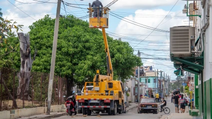 Camión con canasta reparando cables eléctricos en una ciudad, Las Tunas, Cuba