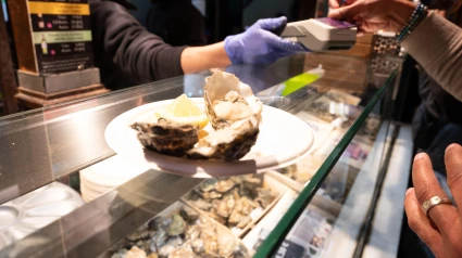 Una bandeja de mariscos recién descascarados y servidos con limón, capturada durante un pago con tarjeta de crédito en España.