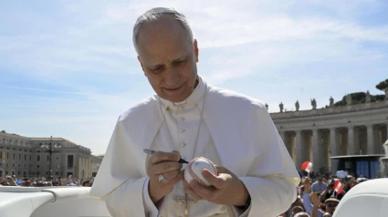 El Papa firma una bola de béisbol que le entregó un fiel