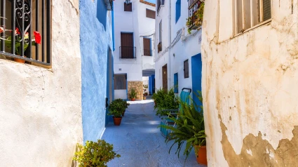 Casas antiguas en una calle estrecha con macetas; pueblo de Chelva en la provincia española de Valencia