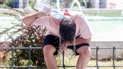 Joven se refresca con agua para mitigar el calor.