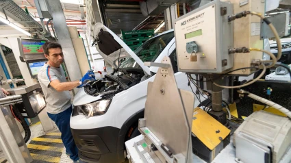 Un operario revisa el motor de un coche Peugeot