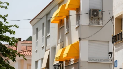 Un edificio con las persianas bajadas y los toldos abiertos