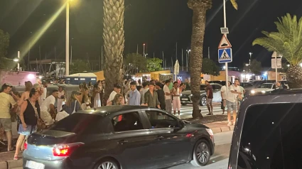 Varios transeúntes, entre ellos turistas, se acercan rápidamente a socorrer al padre y al bebé tras el atropello en pleno paso de peatones