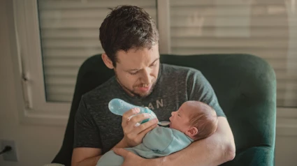 Un padre da de comer a su bebé