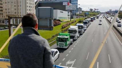 Personas observando a cámara lenta el paso de cientos de camiones en A Coruña