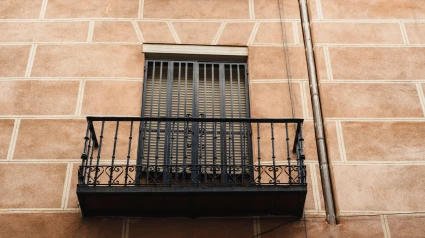 Vista en ángulo bajo de los tradicionales balcones de hierro fundido de un antiguo edificio residencial en el barrio de Lavapiés, en el centro de Madrid, víctimas de okupas