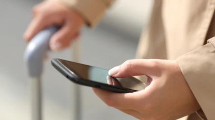 Una mujer mirando todos los detalles de su vuelo desde su móvil