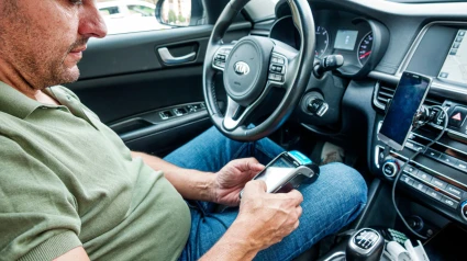 Un taxista con un datáfono para hacer un pago con tarjeta en Barcelona
