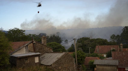 Un helicóptero colabora con las labores de extinción en el incendio de A Cañiza