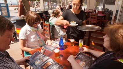 Una camarera sirve la comida a los clientesUna camarera sirve la comida a los clientes