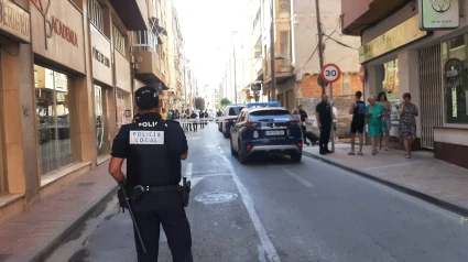 Un agente ante el cordón policial tras el tiroteo del jueves en Lorca