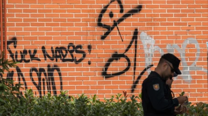 Un agente de la UIP de Policía Nacional al lado de un edificio okupado