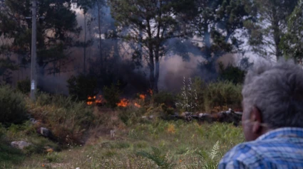 Una persona observa el fuego en Ponteceso, A Coruña, Galicia