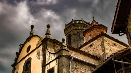 Fachada y torres de la iglesia de Rupit, en Cataluña, bajo un cielo nublado