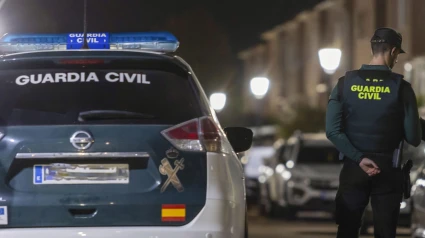 Agente de la Guardia Civil junto a su vehículo