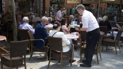 Un camarero atiende a una clienta en España