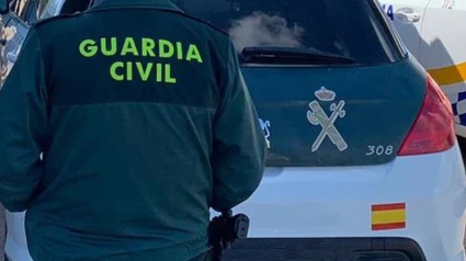 Un agente de la Guardia Civil junto a un vehículo oficial