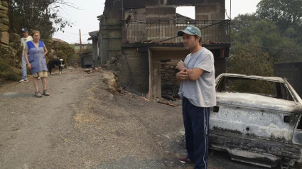 Vecinos de la aldea de La Caridad, donde han ardido casas, vehículos y animales
