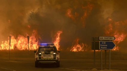 Vecinos y bomberos intentan aplacar el fuego que afecta a la aldea de Lamas (Cualedro), en Ourense.