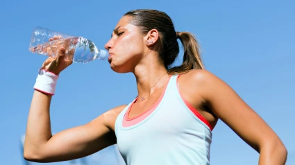Una joven bebiendo agua después de hacer deporte