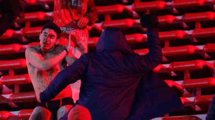 Hinchas argentinos golpean a los chilenos en una de las tribunas.
