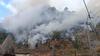 Una gran nube de humo en torno a uno de los pueblos rodeado por los incendios en Asturias