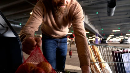 Hombre empacando bolsas de compras en un automóvil