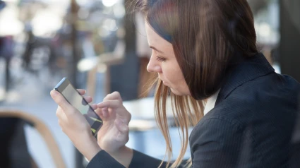 F587AD business woman using smartphone during lunch in cafe