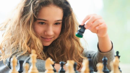 E5WRJ7 E5WRJ7 Portrait of young girl playing chess