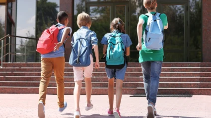 Cuatro niños entrando en su centro escolar
