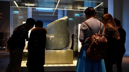 epa07148550 Visitors look at the Rosetta Stone at the British Museum in London, Britain, 07 November 2018. The ancient stone contains hieroglyphic script and Ancient Greek allowing the Rosetta Stone to be the key in deciphering Egyptian hieroglyphs. The Grand Egyptian Museum is calling for the return of the Rosetta Stone to Egypt after being displayed in the British Museum for more than 200 years, local media reported. EPA/NEIL HALL