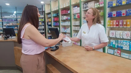 Una usuario usa su tarjeta de MUFACE en una farmacia de Zaragoza