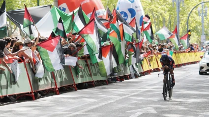Un ciclista pasa entre los manifestantes durante la 18ª etapa de la Vuelta a España,