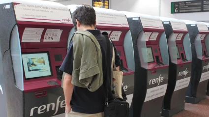 Un pasajero, delante de una máquina de billetes de Renfe