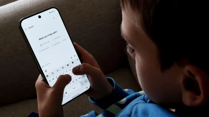 Interfaz ChatGPT utilizada por un niño pequeño en un teléfono inteligente mientras está sentado en el sofá.