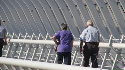 Una pareja de jubilados caminando por un puente moderno en Bilbao